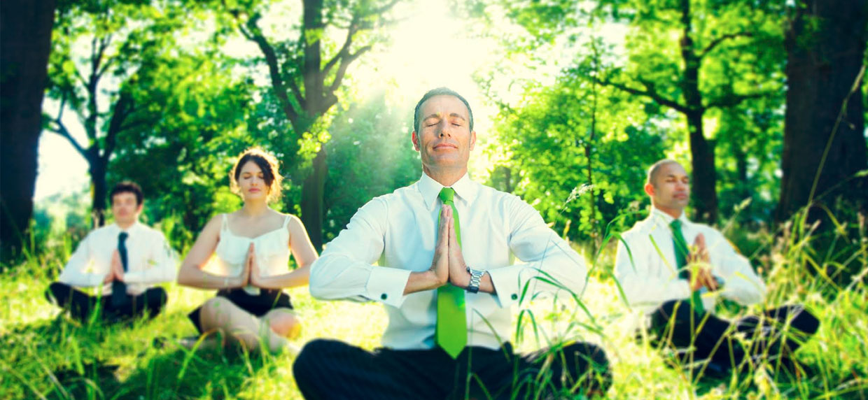 Business-men and woman doing yoga in the wilderness
