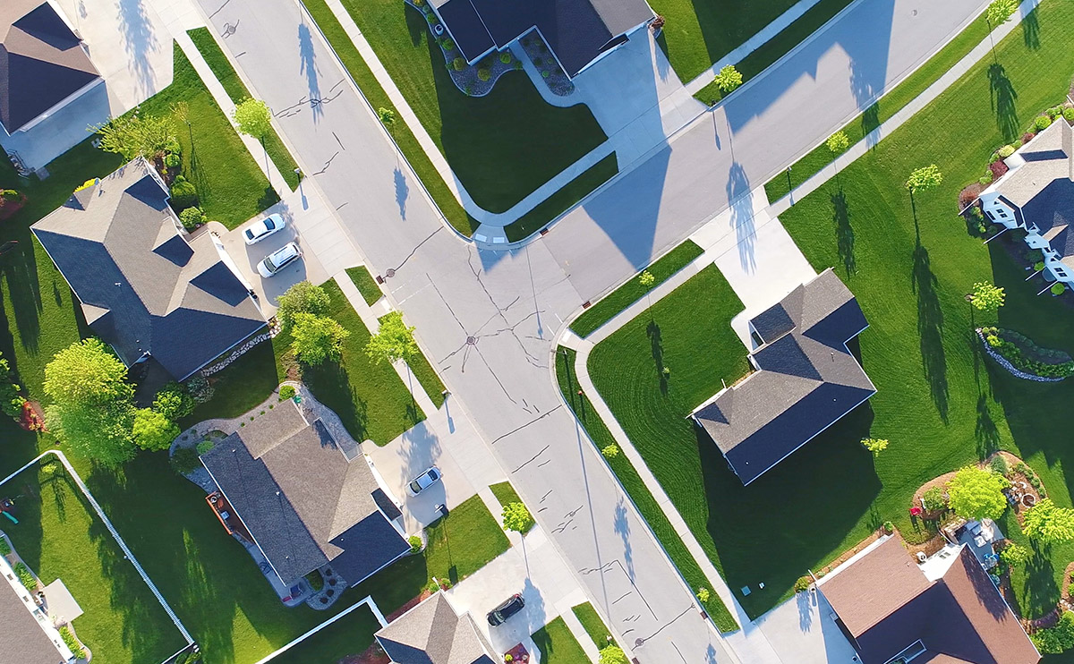 Aerial view of suburban neighborhood with green lawns