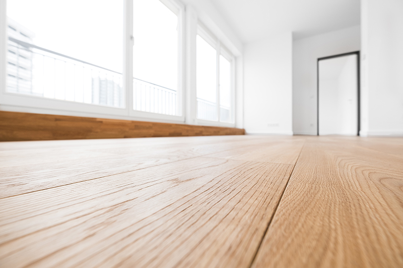 Empty apartment with wood floors and white walls and door