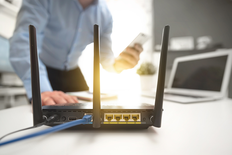 Wireless router with blurred out man holding phone in background
