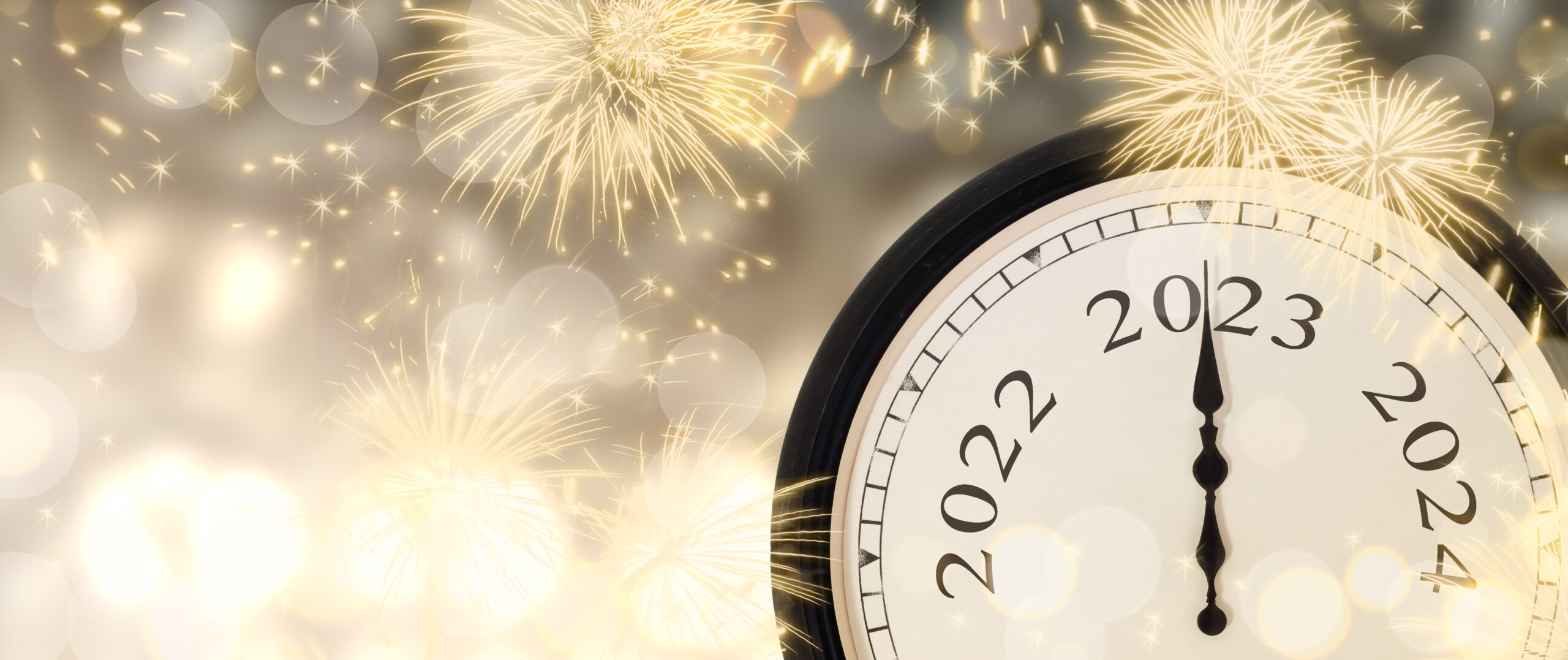 New Year`s Eve 2023 concept. Clock hands on year number 2023. Gold magic background with fireworks and blurred lights.