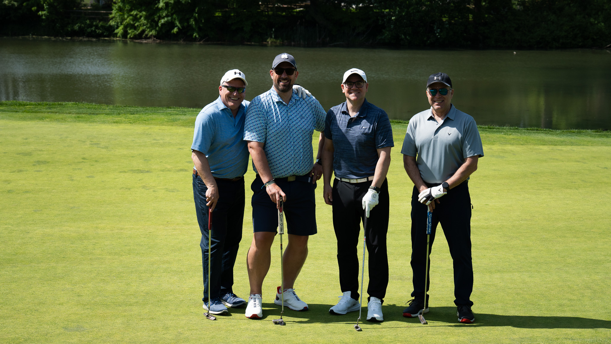 Four Arbor employees on a golf course. 